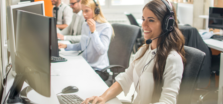 Call center staff sitting at desks and answering calls